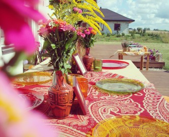 Spalvotos lėkštės ir marga staltiesė, ryškus šventės dekoras